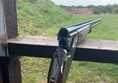 Picture of a rifle resting on a wooden bar