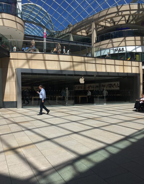 The front of the Apple store in the trinity centre. It is glass fronted with a doorway in the centre