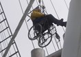 A wheelchair user climbing the mast.