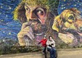 Image of two people in front of a mural