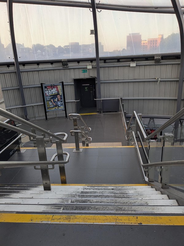 Image of stairs at the station, there are markings at the top and bottom steps and rails on either side