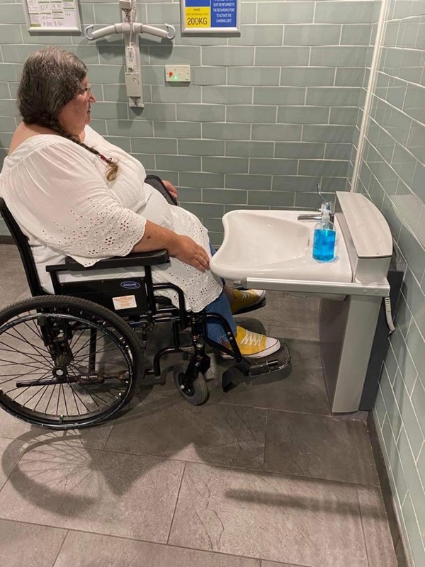 Picture of a wheelchair user in front of a height adjustable basin