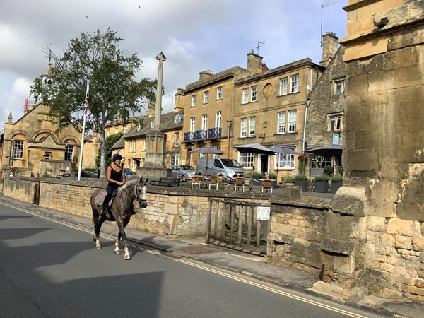 Someone on a horse riding down a street