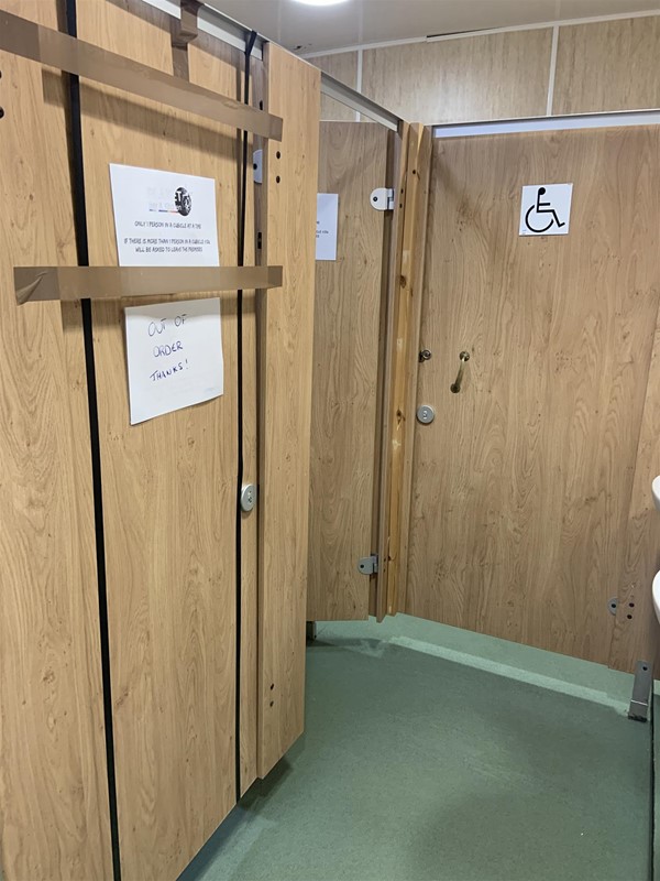 Image of a wooden door with an accessible toilet sign in it