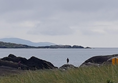 View from the dunes near Derrynane House across the rocky outcrops on the beach to mountains on the peninsula in the distance