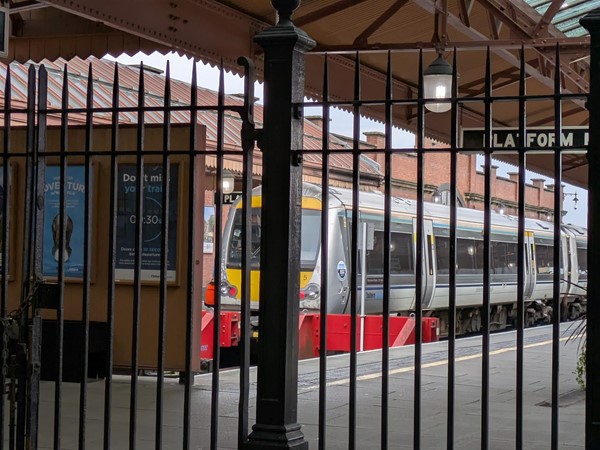 Image of platform 1 where a train is waiting through a gate