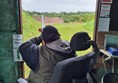 Picture of a man in a Powerchair firing a rifle