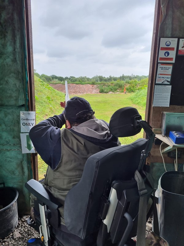 Picture of a man in a Powerchair firing a rifle