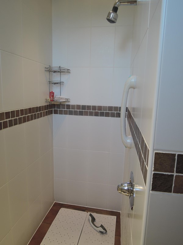 Shower area after staff had added clip on grab rails + shower mats, 1 of the grab rails kept falling off