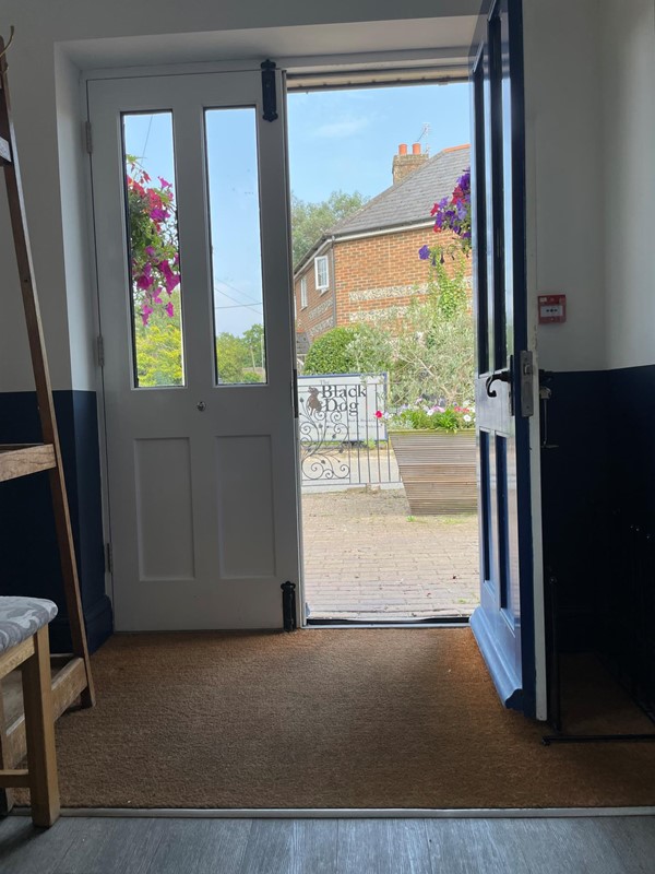 Image of a door with glass panels and a chair in front of a building