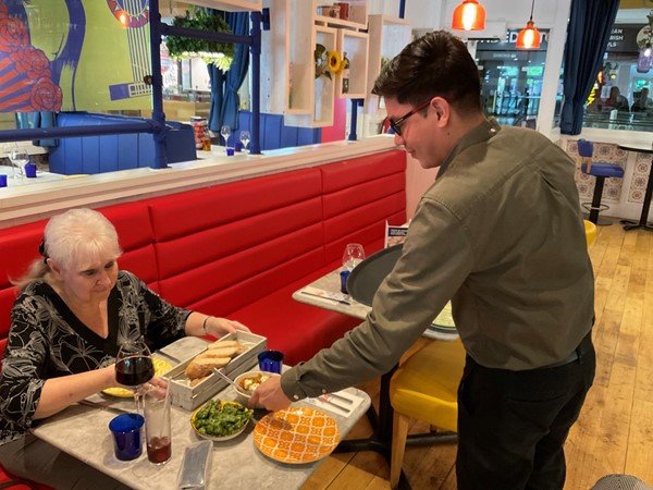 Image of lady being served in dining area