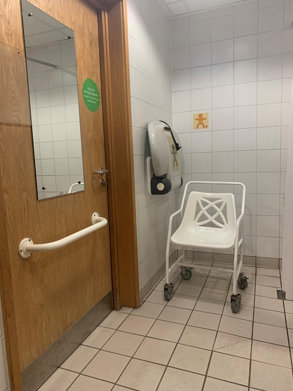 Taken from the bathroom side of the room. There is a rollable? shower seat which you can sit on and be pushed out to the pool area. There is also a baby changing bed next to it.