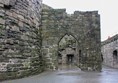Mostly stone path going through archway.