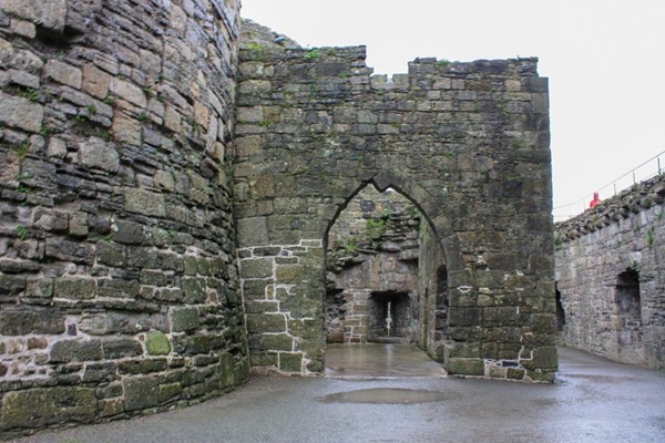 Mostly stone path going through archway.