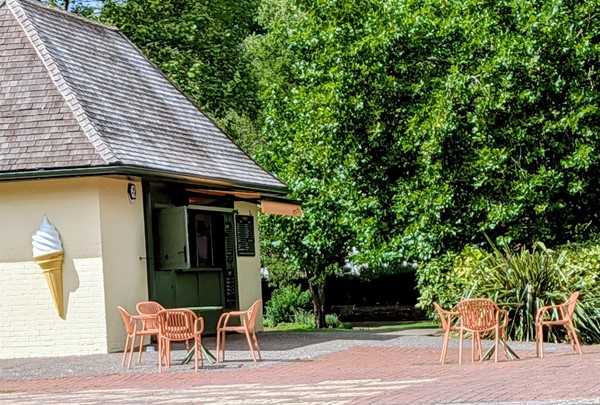 Image of the kiosk from far away with tables and chairs outside