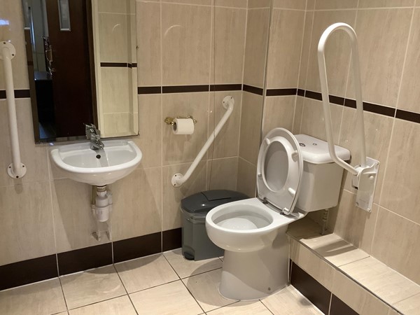 which was nice and clean, tidy, with grab rails and a pull cord, spacious enough to use a wheelchair inside, and tiled in nice plain coloured tile