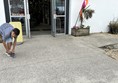 Imafe of someone doing up a shoelace outside a building