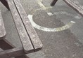 Accessible parking space with benches blocking use.