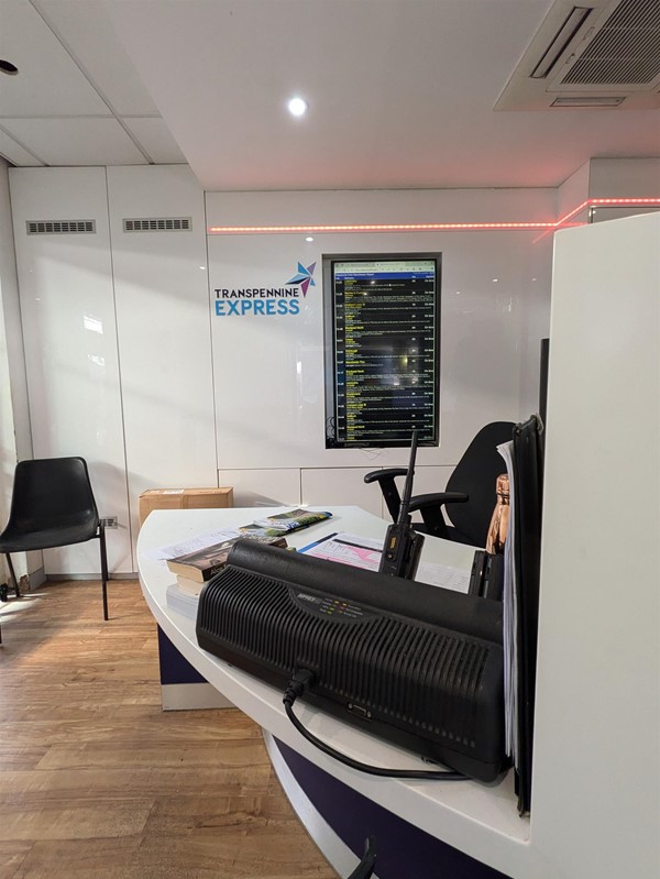 Image of the passenger assistance booth on platform 3b. A low white table in a waiting room.
