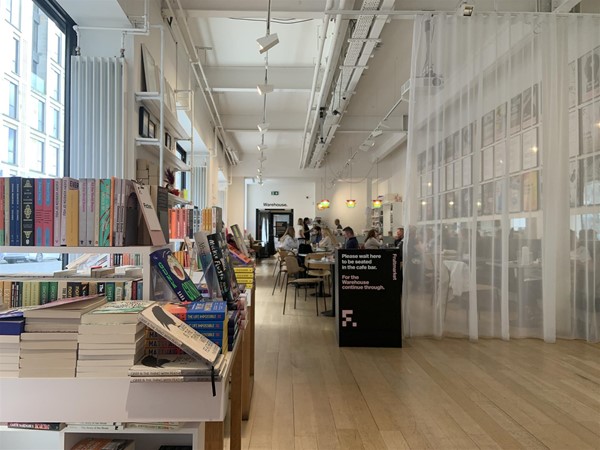 image of a bookshop display with the café in the background