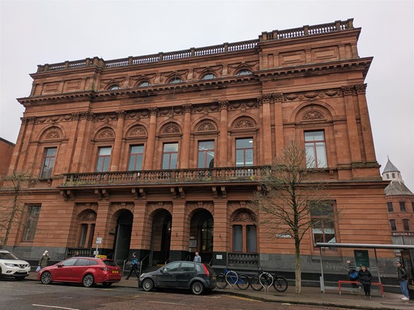 Image of the library from the front, a large sand stone building