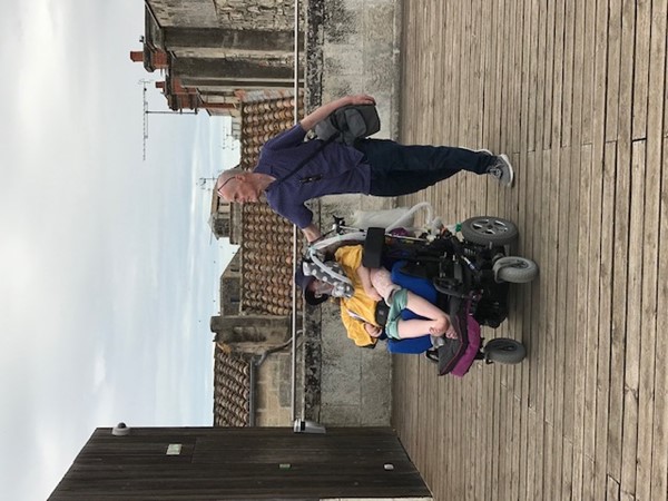 Image of two people, one in a powerchair