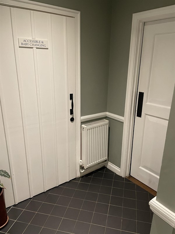 Image of a white door with accessible baby changing