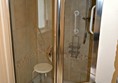Shower with one small step, grab bars and seat.