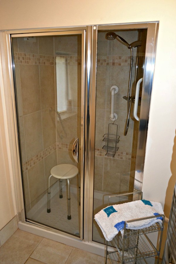 Shower with one small step, grab bars and seat.