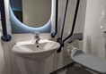 Image of shower, sink and mirror in the accessible toilet of a hotel room