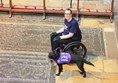 Lady in wheelchair with assistance dog inside the cathedral.