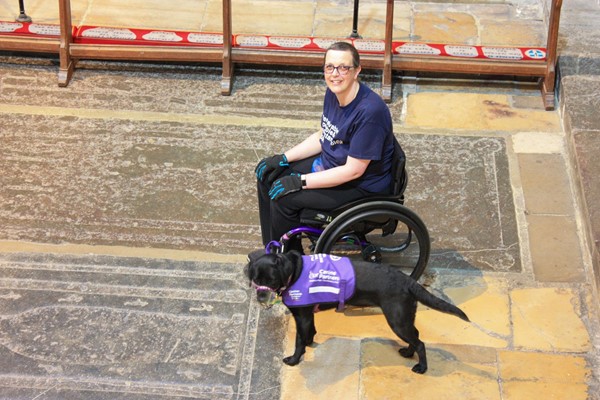 Lady in wheelchair with assistance dog inside the cathedral.