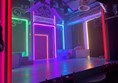 A small stage lit up in rainbow colours