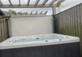 Accessible hot tub which has an outdoor hoist which is stored inside the cottage.