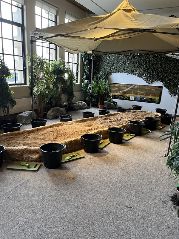 Dig-a-dino activity with sandpit and buckets.