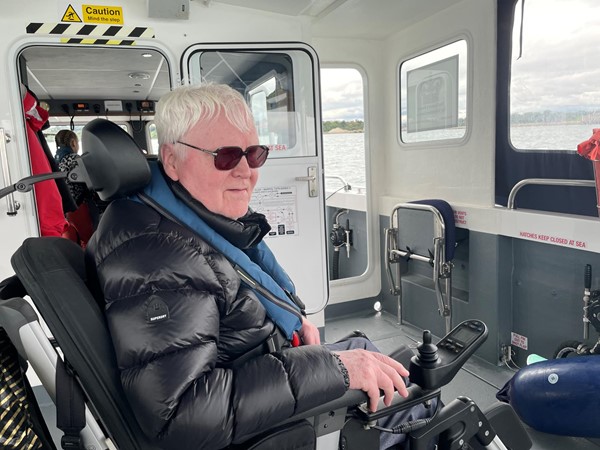 My husband in his wheelchair safely strapped down and enjoying the trip