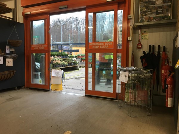 Image of the automatic door leading out into the garden centre showing the sign in the way.