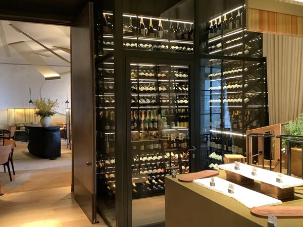 Stepping through the narrow doorway, you face the large wine cabinet