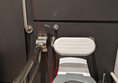 Image of toilet seat, the red cord is wrapped around the toilet seat.