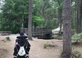 Bridge is wide enough for the biggest of scooters. The slope behind it is the largest. It's uphill if you do the loop anticlockwise or downhill if clockwise. Easy enough in my power chair.