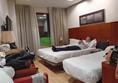 Image of a person lying on two beds in a hotel room