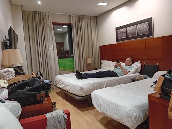 Image of a person lying on two beds in a hotel room