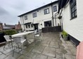 Image of a white building with outdoor seating