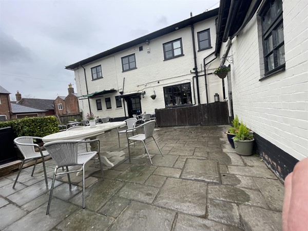 Image of a white building with outdoor seating
