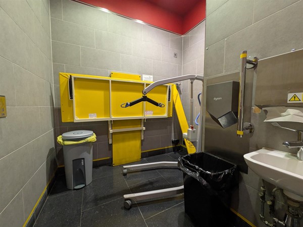 Image of height-adjustable bench in Changing Places Toilet with portable hoist