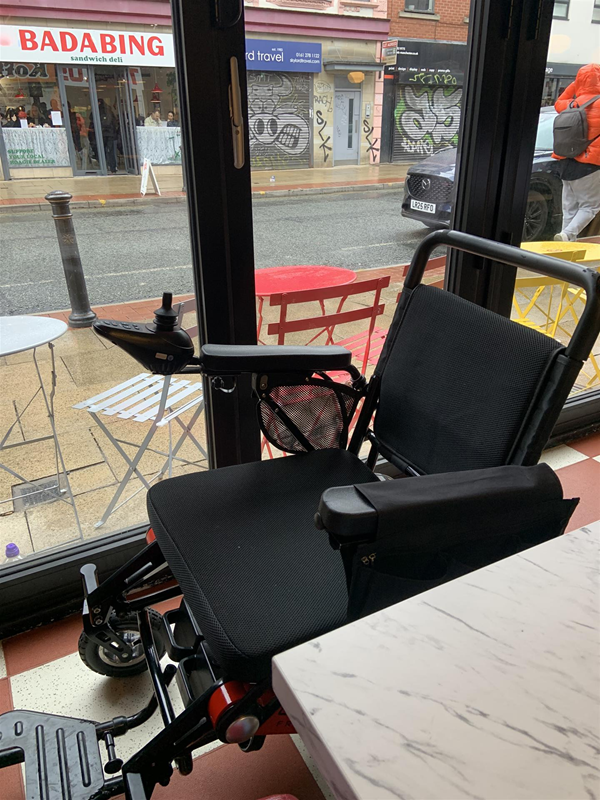image of an electric wheelchair between the table and the window