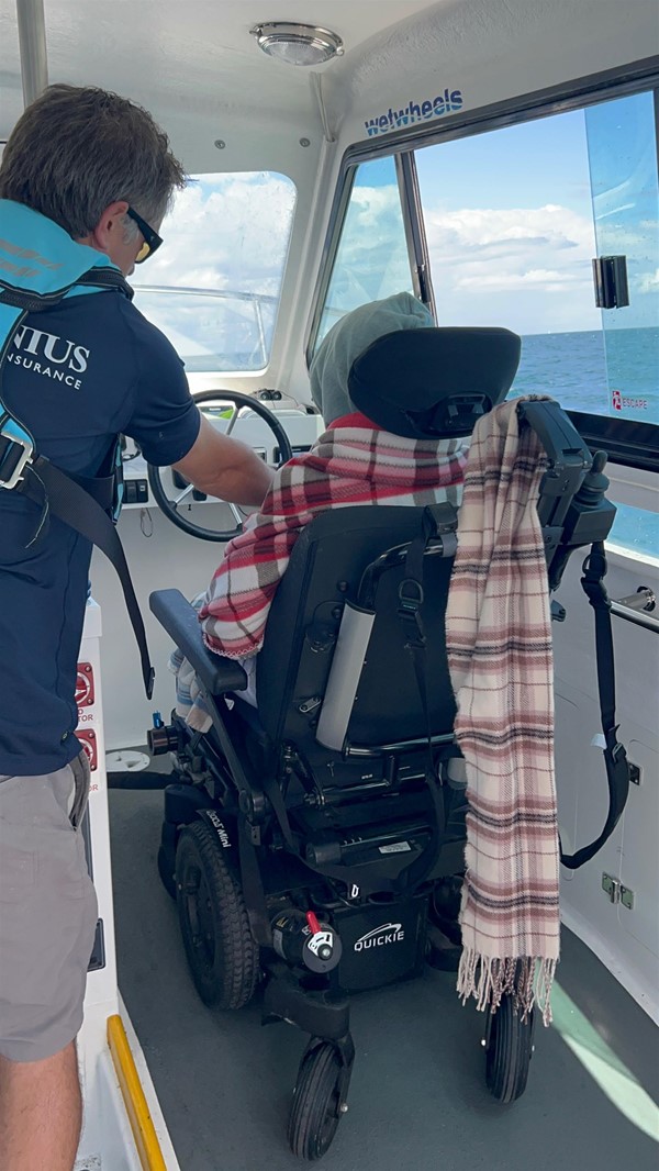 Image of a wheelchair user sterring a boat