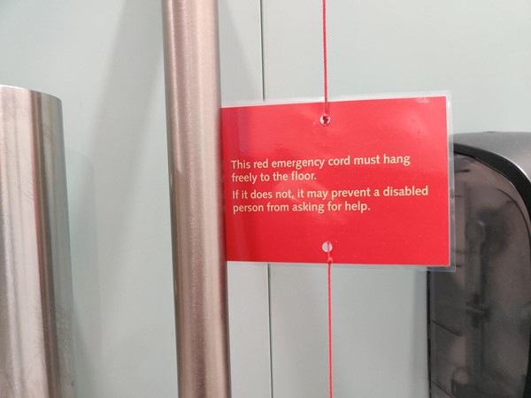 The card on the red emergency cord in the accessible toilet.