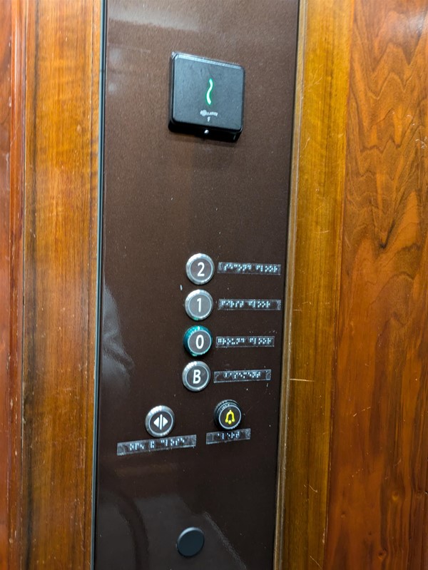 Image of lift buttons. The lift buttons have braille markings
