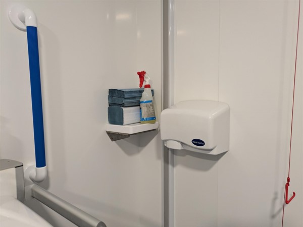 Image of Colostomy shelf which is being used to hold paper towels and disinfectant spray